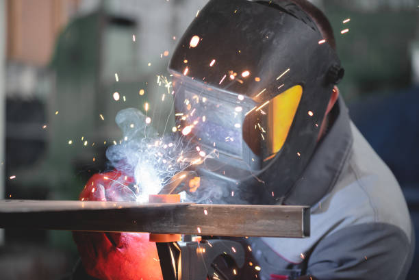 Metal welding with safety gear Worker welding metal with protective gear